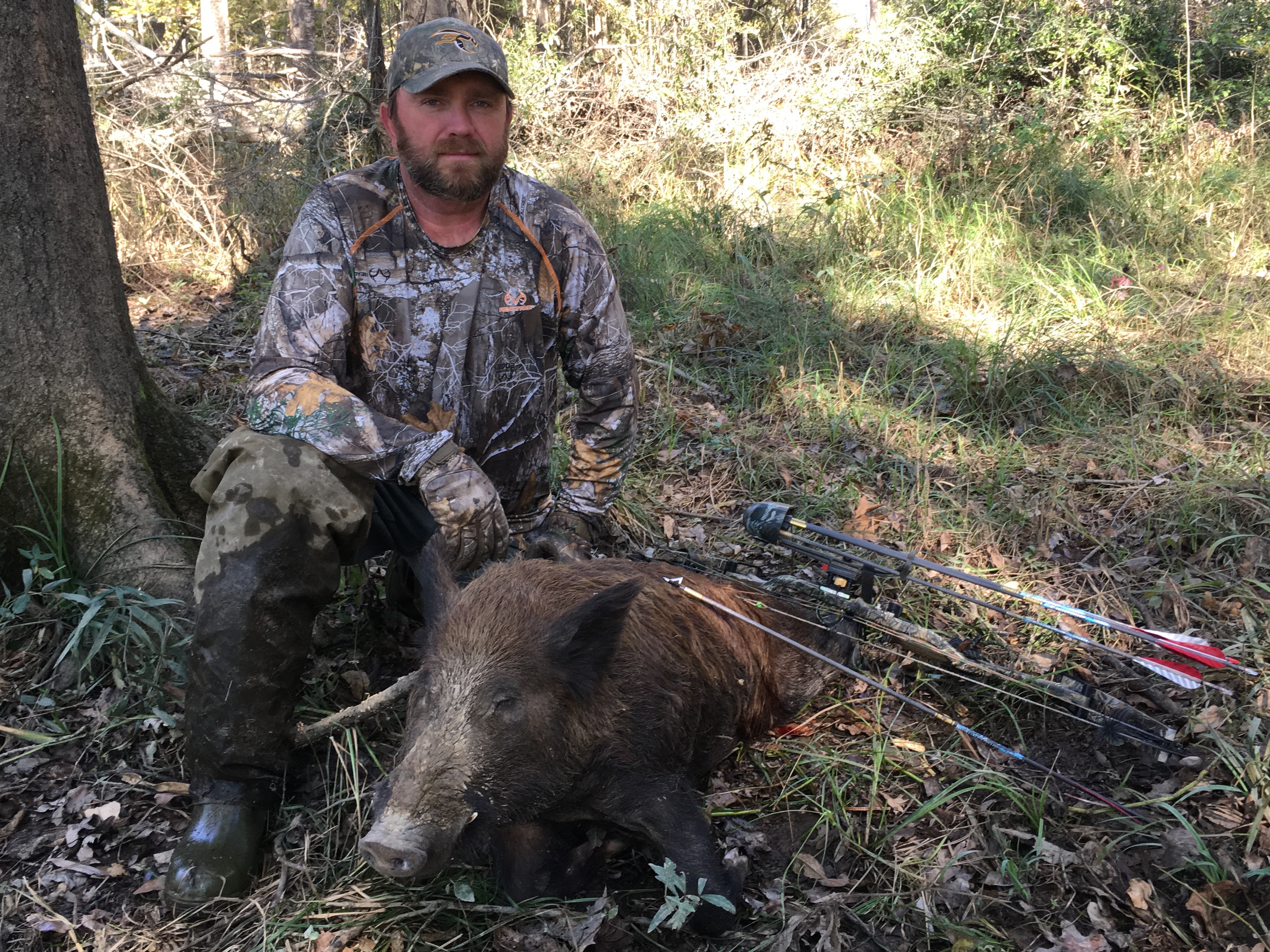 bowhunter posing with hog